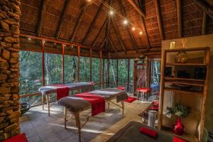 a room with chairs and tables in a room with trees at Trogon House and Forest Spa in The Crags