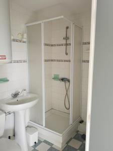 een badkamer met een douche en een wastafel bij 2 pièces Front de Mer ensoleillé et calme accès direct plage in Cabourg