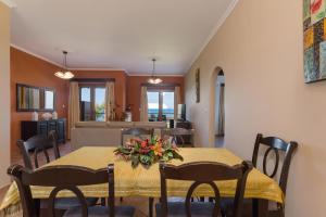 a dining room with a table with flowers on it at Venetico Beachfront Apartments & Suites - 2 Bedroom Apartment in Argassi