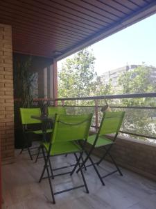 3 grüne Stühle und ein Tisch auf dem Balkon in der Unterkunft Apartamento Alba in Alicante