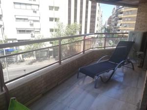 uma cadeira azul sentada na varanda de um edifício em Apartamento Alba em Alicante