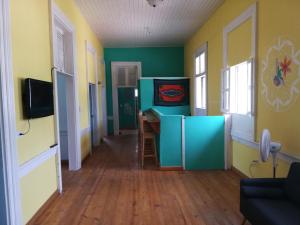 ポルトープランスにあるPark Hostelの緑と黄色の壁とウッドフロアの客室です。