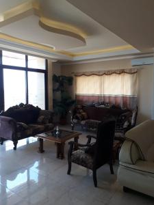 a living room with couches and a coffee table at Koura Nahla Apartment in An Nakhlah