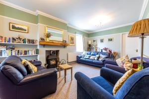 a living room with two blue couches and a fireplace at Edale House B&B in Parkend
