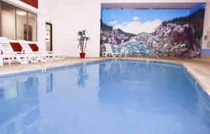 Libby的住宿－Venture Inn，一个带椅子和壁画的大型游泳池