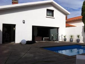 a white house with a swimming pool in front of it at Villa Zen in Narbonne