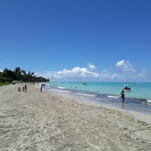 a group of people walking on the beach at flat na praia de maragogi in Maragogi