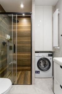 a bathroom with a washing machine and a washer at Luxury Apartment with Large Terrace in Wrocław
