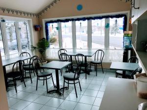 un comedor con mesas, sillas y ventanas en Motel Belle Riviere, en Saint-Jean-sur-Richelieu