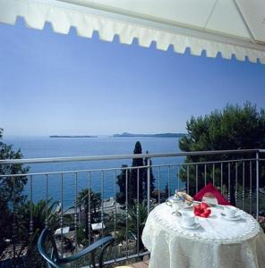 a table on a balcony with a view of the ocean at Hotel Miralago in San Zeno di Montagna