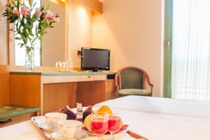 a tray with drinks and fruit on a table at Hotel Miralago in San Zeno di Montagna
