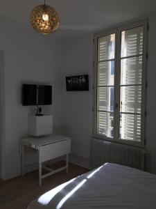 a bedroom with a bed and a television and a window at Le Bahia centre la Brèche wifi linge de pressing in Niort