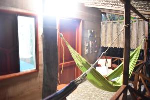 a green hammock hanging in a room at Posadas Ecoturisticas Seineken in El Zaino