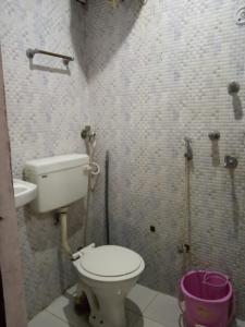 a small bathroom with a toilet and a sink at Kanha Paying Guest House in Varanasi