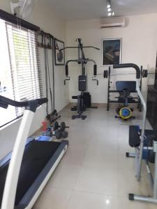 a gym with several treadmills and machines in a room at Hotel Alcaldeza - Garden House in Santo Domingo