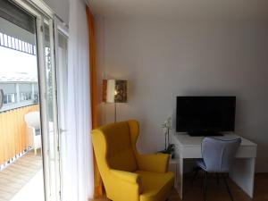 a living room with a yellow chair and a television at Jacuzzi studio apartman Mare's in Zagreb