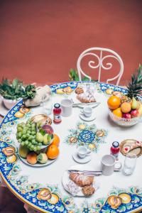 a table with plates of food on top of it at Scene Suites Apartments in Catania