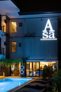 a sign on the side of a building with a swimming pool at Asa Hotel in Chiang Mai