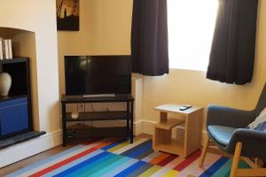 uma sala de estar com televisão e um tapete colorido em Chester City Centre House, Recently Furnished em Chester