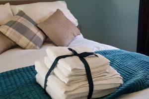 uma pilha de toalhas sentadas em cima de uma cama em Chester City Centre House, Recently Furnished em Chester