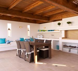 a dining room with a wooden table and chairs at Luxury Villa Eos in vlicha