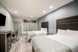 ヒューストンにあるAmericas Best Value Inn & Suites NE Houston Downtown I-610のベッド2台と薄型テレビ付きのホテルの部屋