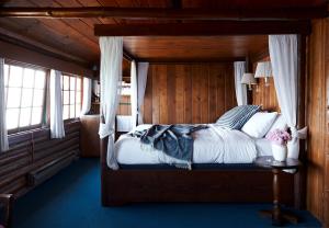 a bedroom with a bed in a wooden room at Captain Whidbey in Coupeville