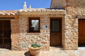 una casa de piedra con una maceta delante de ella en Casa Cerrito en Cortes de Arenoso