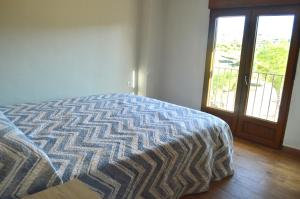 een slaapkamer met een bed en een glazen schuifdeur bij Casa Cerrito in Cortes de Arenoso