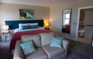 Habitación de hotel con cama y sofá en The Marine Boutique Hotel en Ballybunion