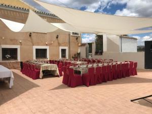 a group of tables with red chairs and white tents at Hotel Reina Victoria in Hellín