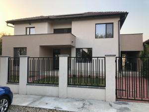 a large white house with a black fence at Pensiunea Sofia in Remetea Mare