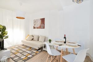 a white living room with a table and a couch at La Casa De Esme ll in Haro