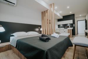 a bedroom with a large bed with a black wall at Unique Experience Apartment’s in Thessaloniki