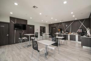 ヒューストンにあるAmericas Best Value Inn & Suites NE Houston Downtown I-610のテーブルと椅子、キッチンが備わる客室です。