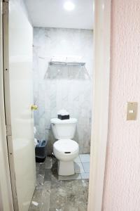 a bathroom with a white toilet in a room at Hotel San Jorge in Tepic