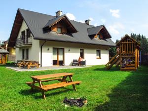 a house with a picnic table in front of it at Domek Plaster Miodu in Istebna