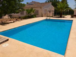 ein blauer Pool vor einem Haus in der Unterkunft Casa Mallaeta in La Pobla de Vallbona