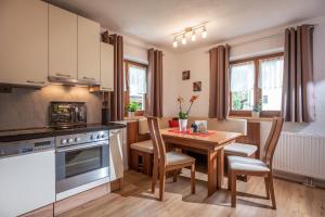 kuchnia i jadalnia ze stołem i krzesłami w obiekcie Salven-Lodge w mieście Hopfgarten im Brixental