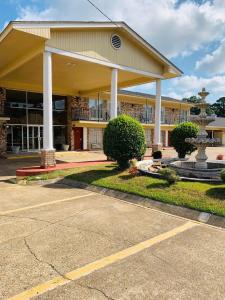 a large building with a fountain in front of it at Coachman's Inn in Magnolia