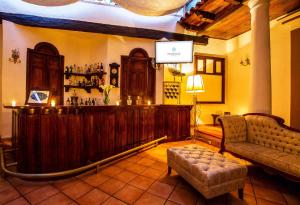 a pub with a bar with a couch and a chair at Grand Guadalupe by Inmense in San Cristóbal de Las Casas