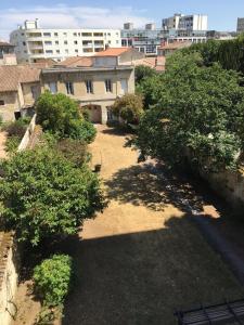 une vue sur une cour arborée et bâtie dans l'établissement Le Galaxy centre la Brèche wifi calme vue jardin, à Niort