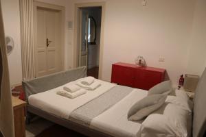 a bedroom with a bed with two pillows and a red cabinet at La Maison in Bergamo