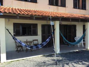 une maison avec un hamac sur la terrasse couverte à l'avant dans l'établissement Casa BEIRA MAR Praia do Grant em Barra Velha-SC, à Barra Velha
