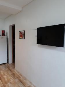 a flat screen tv hanging on a white wall at Apartamento aluguel temporada Torres-RS in Torres