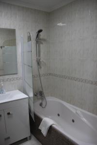a bathroom with a shower and a tub and a sink at Doca do Cavacas Apartment in Funchal +44 photos