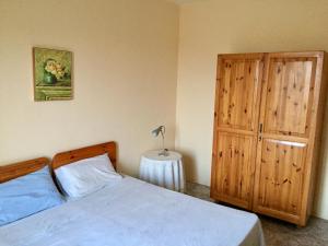 1 dormitorio con 1 cama y armario de madera en Village Apartments en Santa Luċija