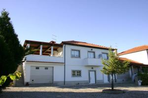 una casa blanca con un garaje y un árbol en Quinta das Murtinheiras, en Lamego