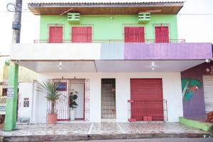 a building with red doors and a balcony at Conforto Total - Família Mangas Monteiro in Macapá