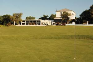 un campo de golf con una bandera en un green en San Isidro Hotel, en Mercedes